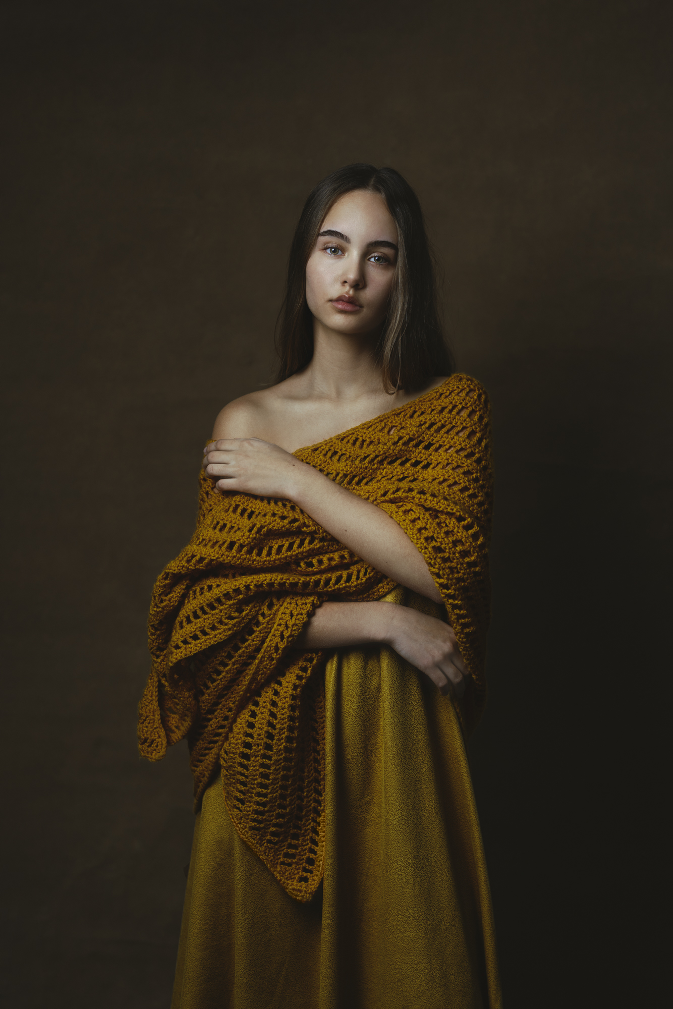 Portret meisje met okerkleurige gehaakte sjaal