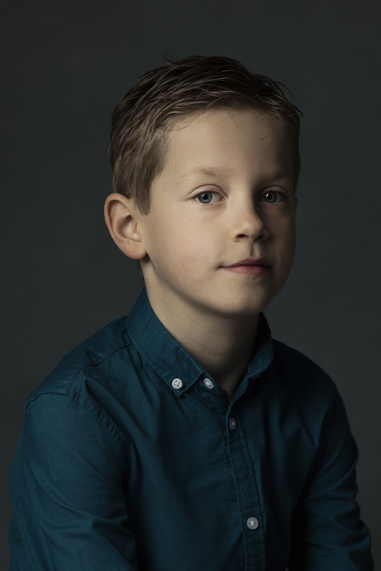 Portret jongen in petrolblauw overhemd